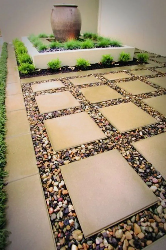 Courtyard paving slabs arranged within decorative pebbles