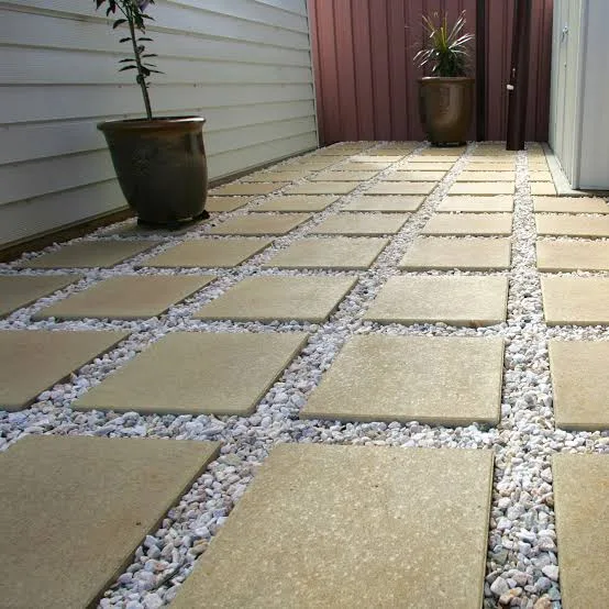 Square paving slabs laid in a decorative gravel path
