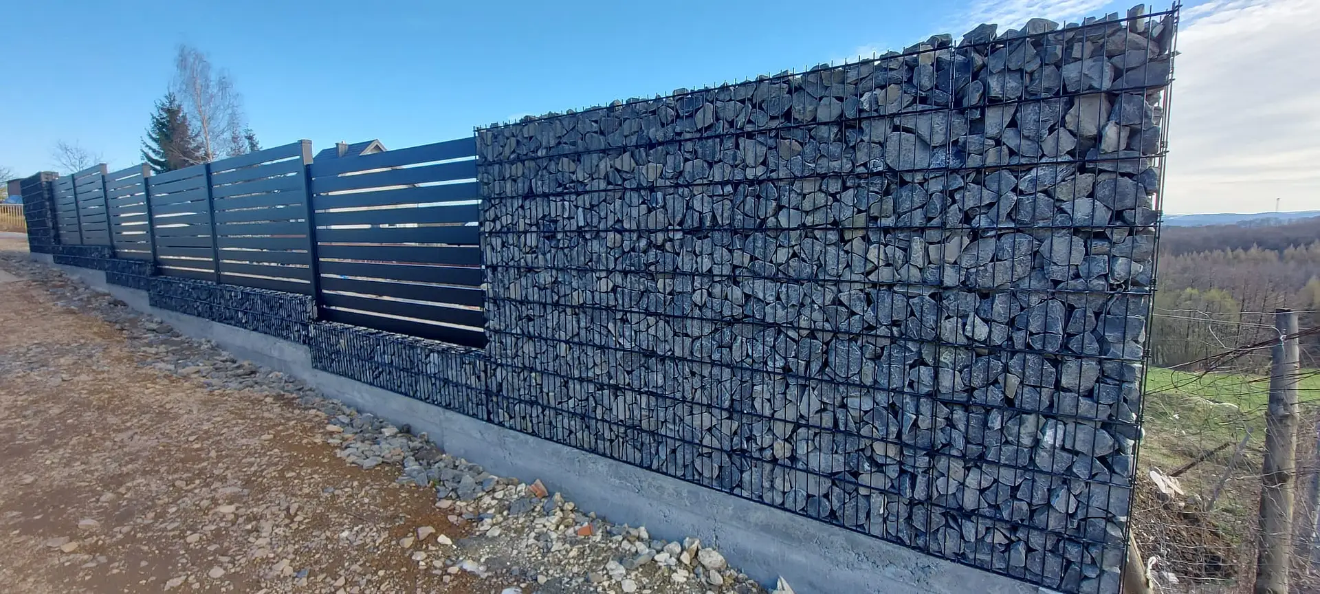 Illustrative project: Completed stone-filled gabion entrance with a black steel gate