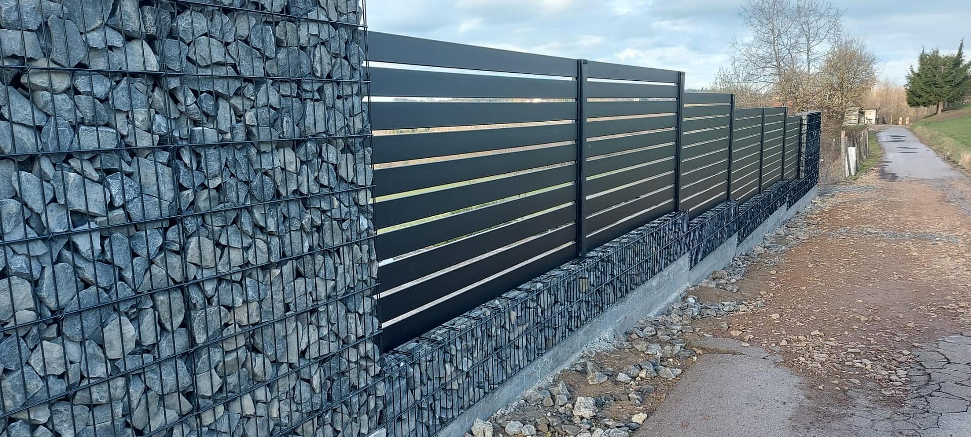 Gabion pillars and dark driveway gate