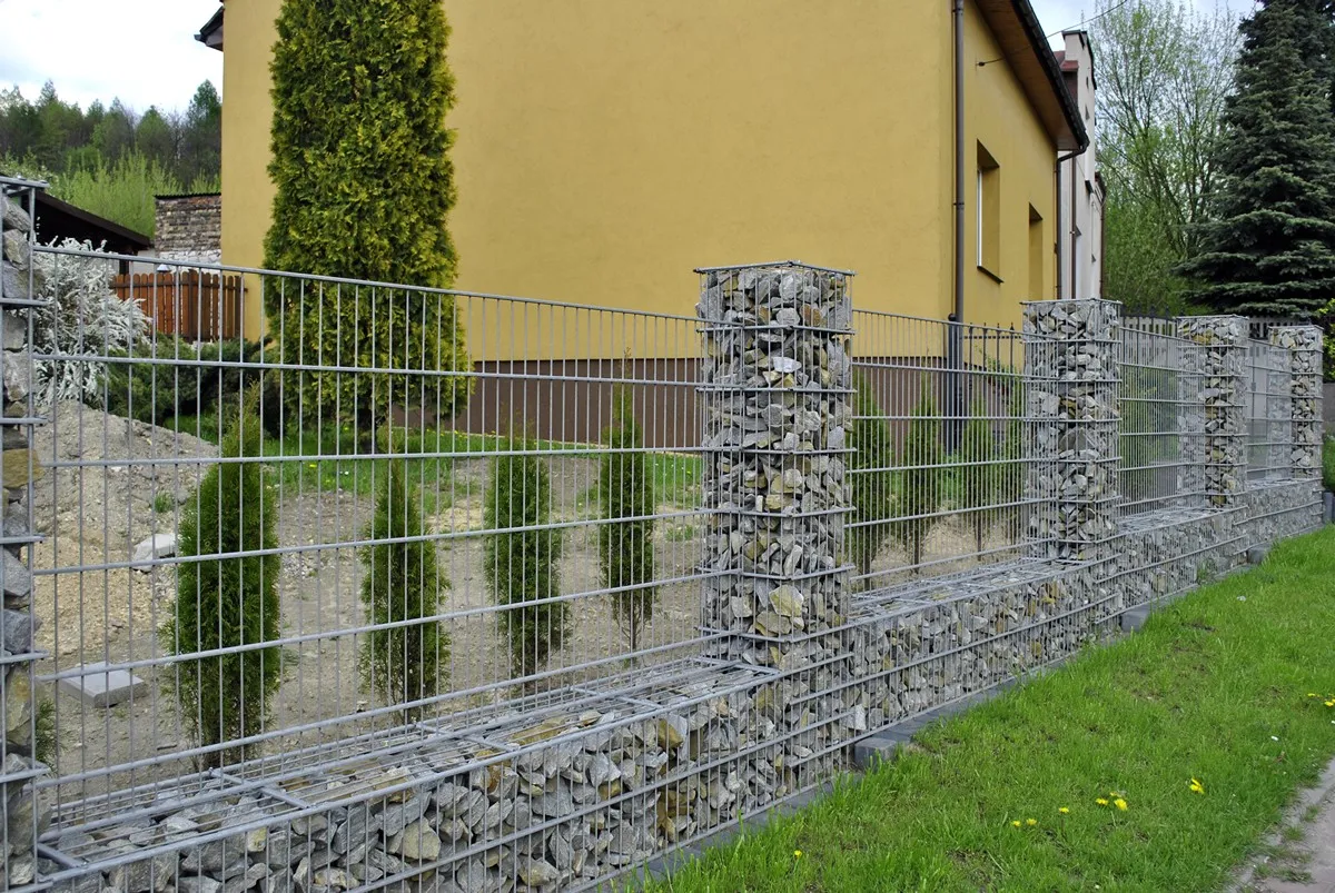 Open steel fence with gabion columns and base